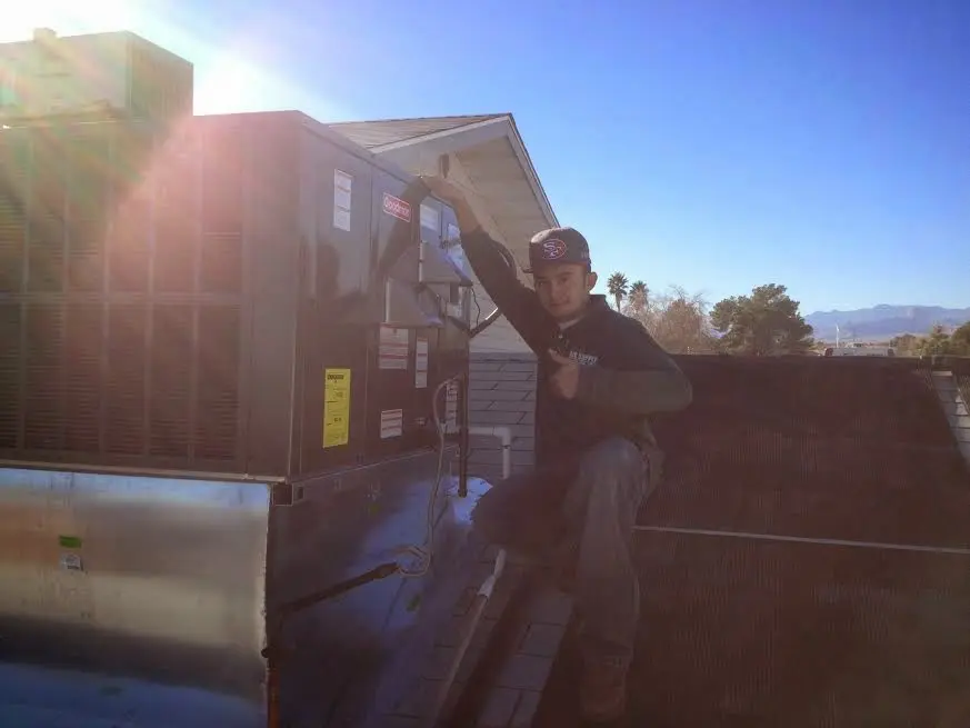 HVAC technician performing AC Tune-Up on a rooftop unit in Penn Forest